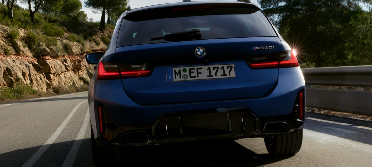 BMW M340i xDrive Touring G21 Frozen Tanzanite Blue Heckansicht fahrend auf Straße